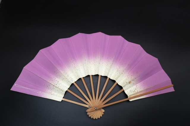 広げた紫色の扇子